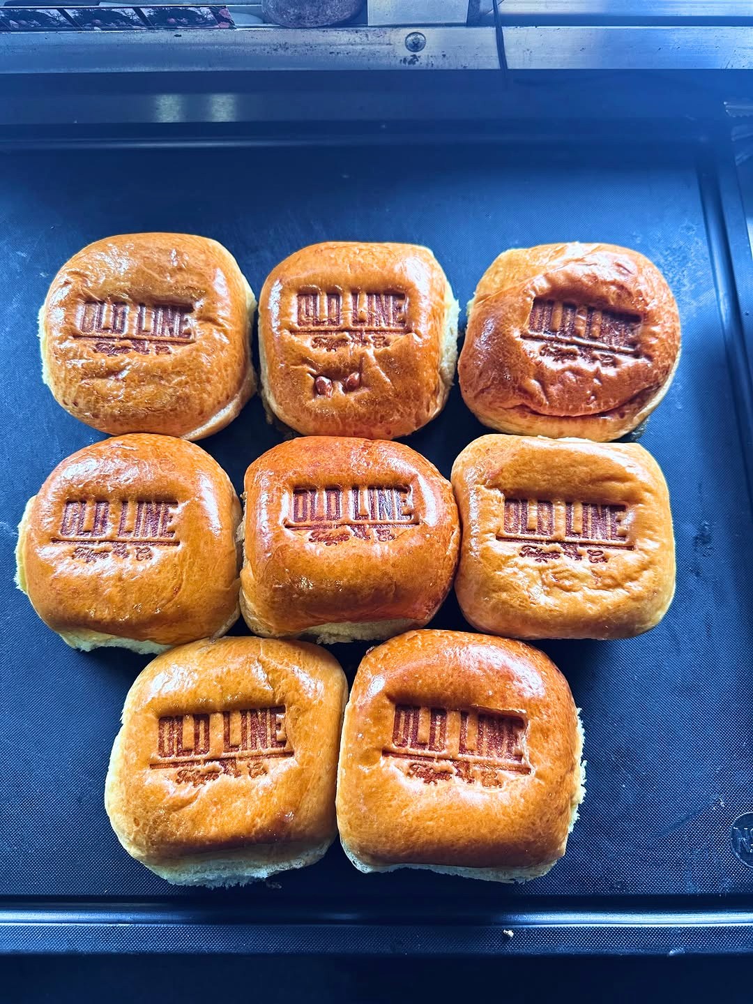 Eight toasted buns, each branded OLD LINE