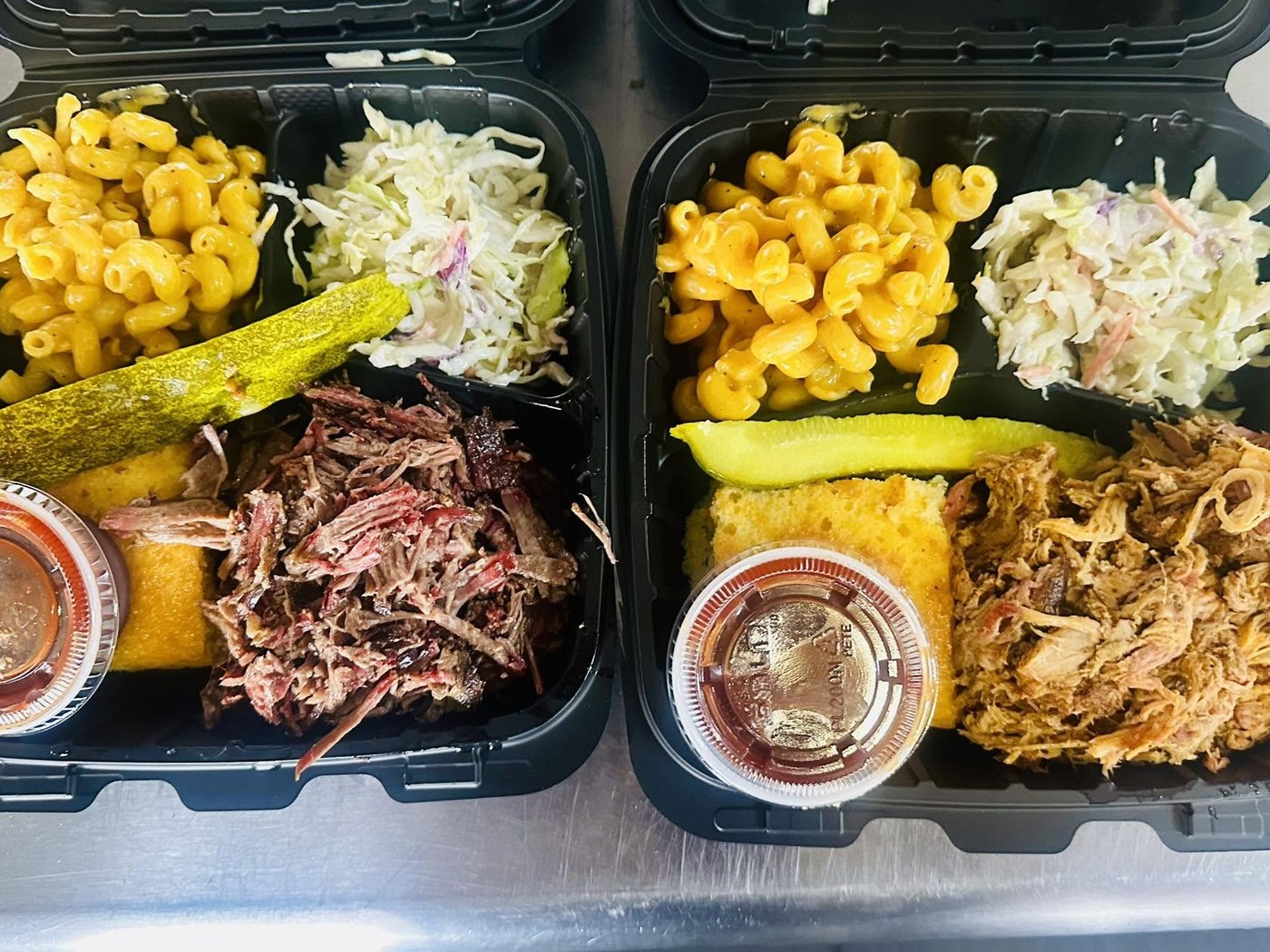Two Old Line clamshell plates – brisket and pulled pork with mac & cheese, coleslaw, cornbread and a pickle spear