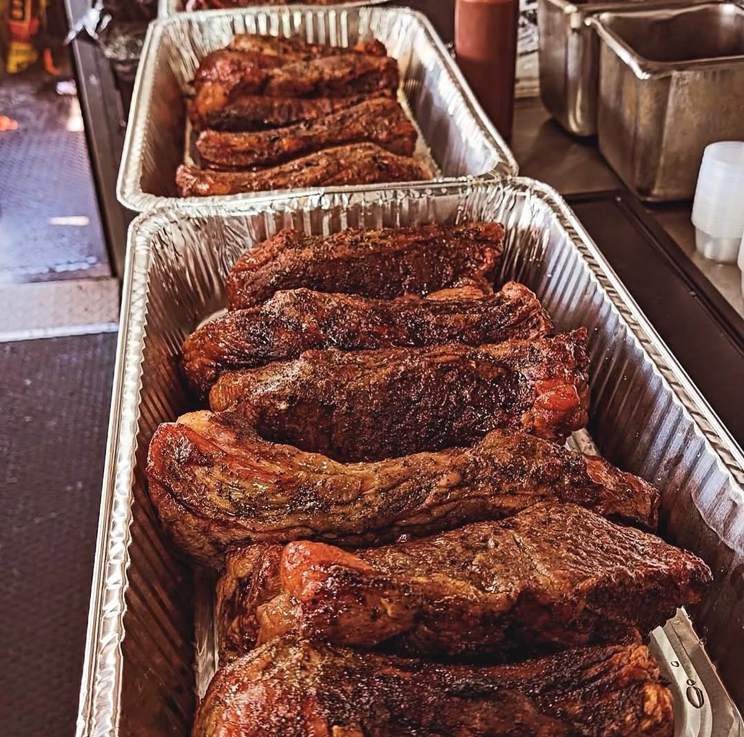 Pans of smoked beef short rib, dark bark, just off the pit