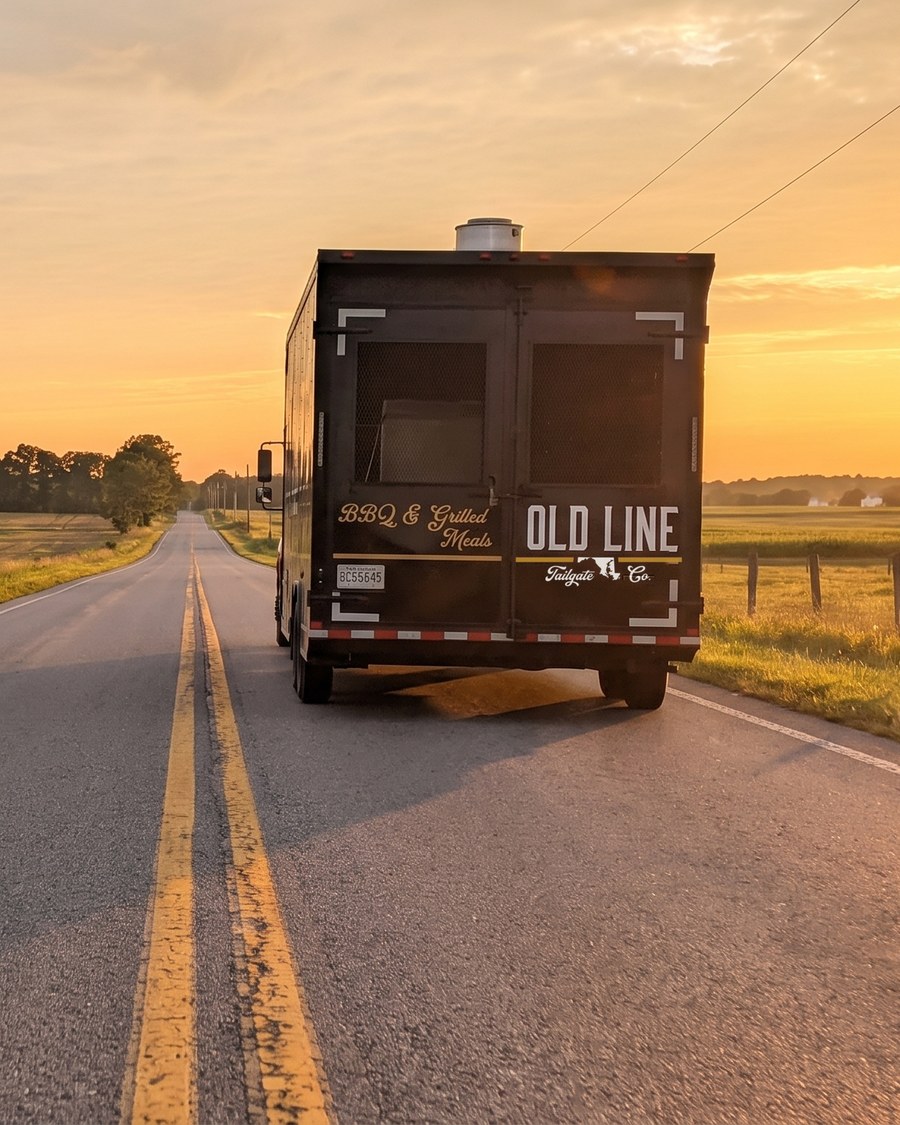 The Old Line trailer heading west on an open two-lane road at sunset