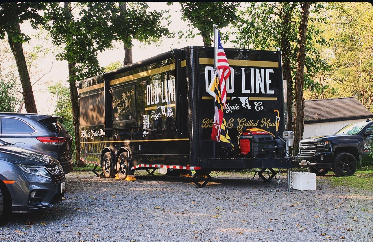 The Old Line food truck trailer at golden hour, flags flying