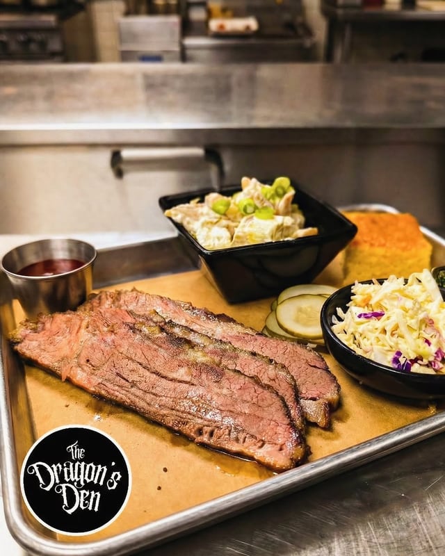Sliced brisket with potato salad, slaw and cornbread on a tray