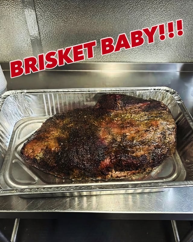A whole smoked brisket in a foil pan: brisket baby