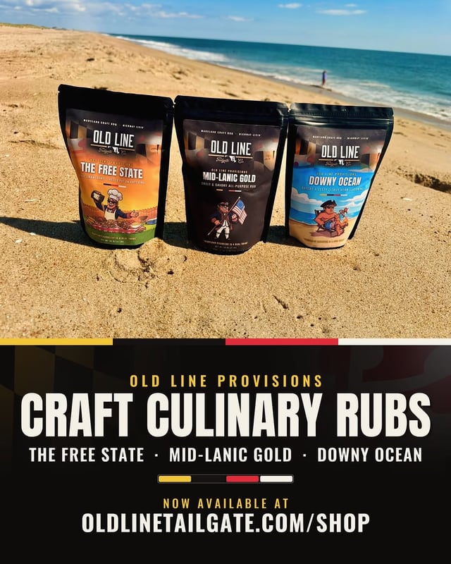Three bags of Old Line Provisions rubs standing in the sand at the ocean