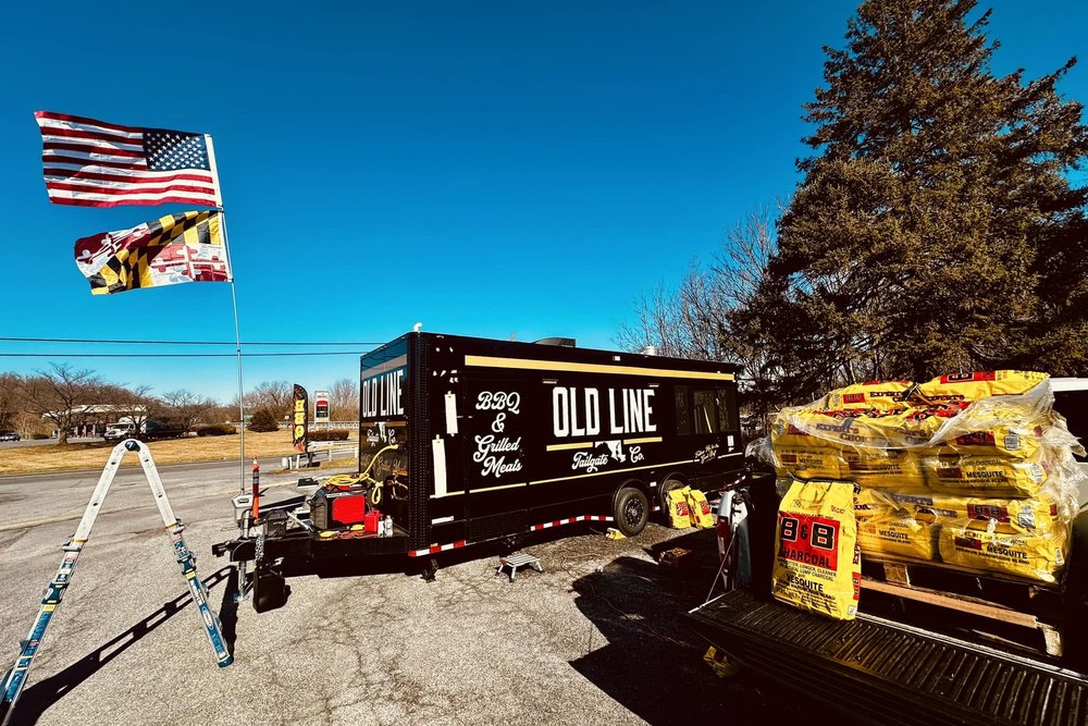 The Old Line truck set up at an outdoor event under the Maryland flag
