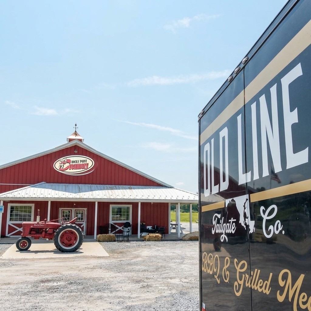 The Old Line Tailgate co. barbecue trailer at Rocky Point Creamery – customers with ice cream and plates crossing the gravel lot in front of the red farm market