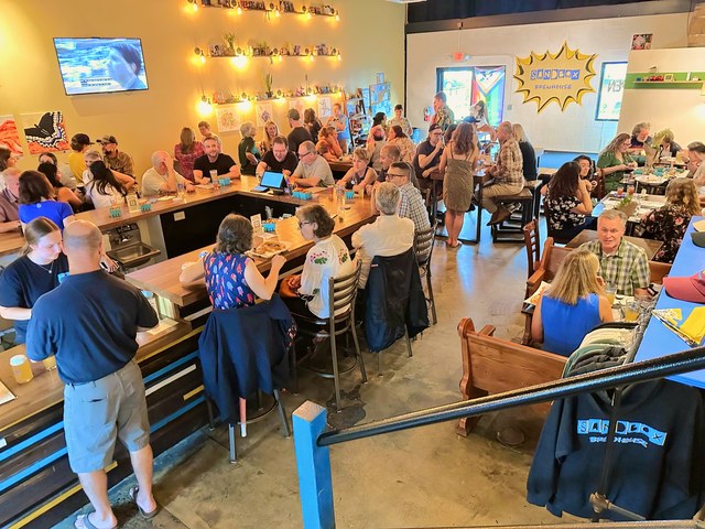 A full house at Sandbox Brewhouse: every seat at the bar taken, tables crowded under the string lights