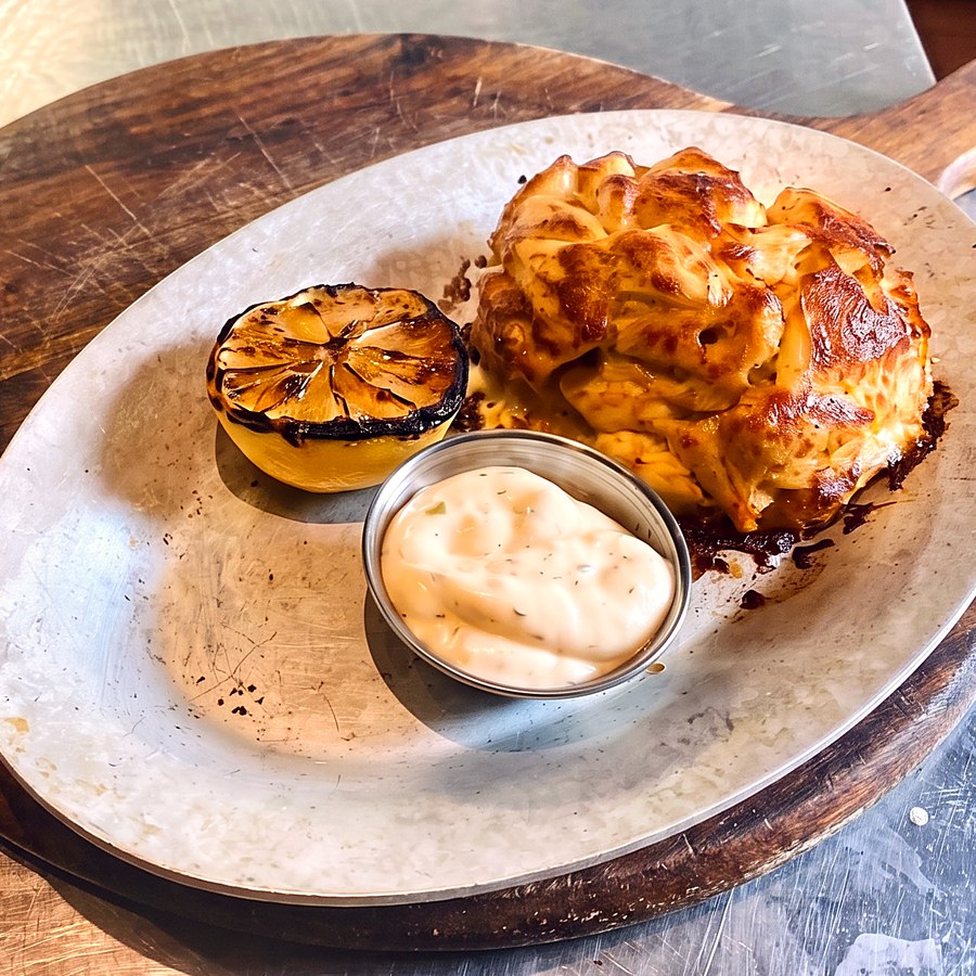 A broiled jumbo-lump Maryland crab cake with charred lemon