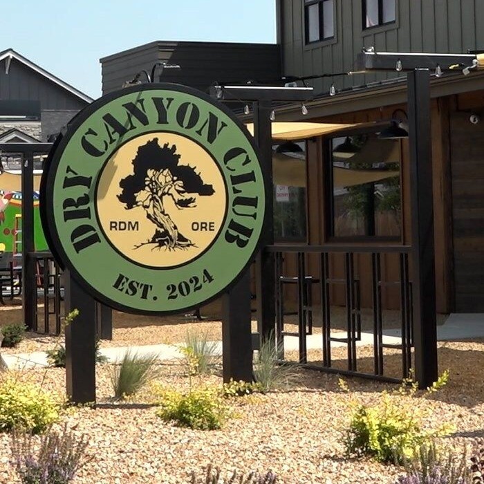 Dry Canyon Club in Redmond: the round tree sign out front of the tap house and its covered patio